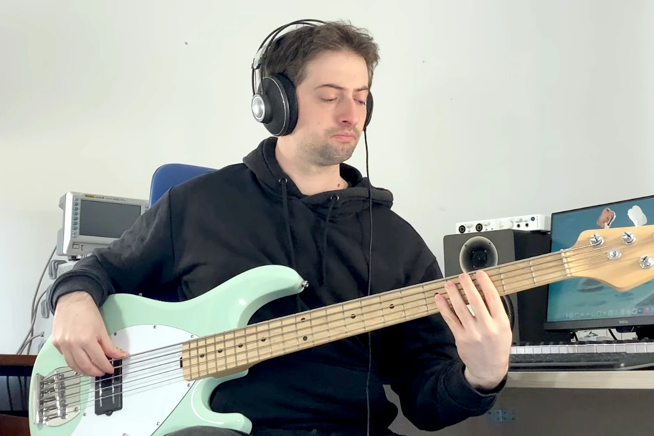 Stefano playing bass at his work desk
